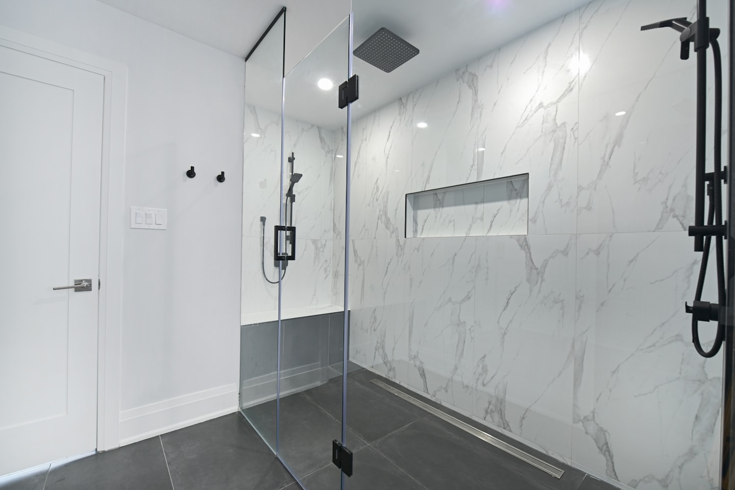 Bagno moderno con doccia in marmo a tutta parete.